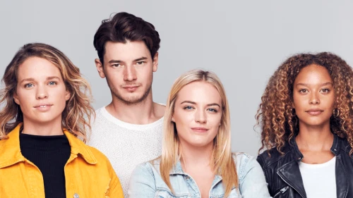 Four young people standing in a line, looking at the viewer