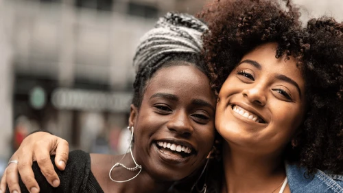 Two friends, arm-in-arm and smiling