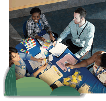 Workers collaborating around a table, taken from directly above all of them.