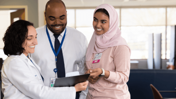 Doctors reviewing a medical chart with friendly, smiling faces.