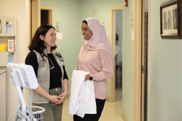 Doctor and Resident smiling in a CHA hallway at a care center