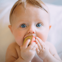 Baby with small block in mouth