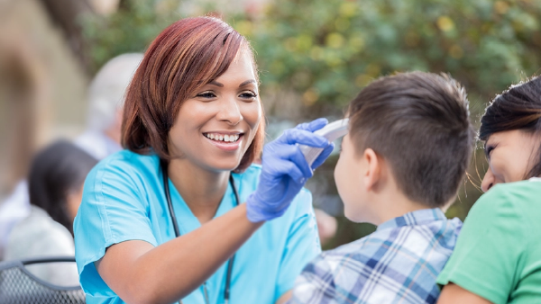 Medical professional taking a childs temperature 