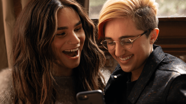 Two gender diverse young people talking
