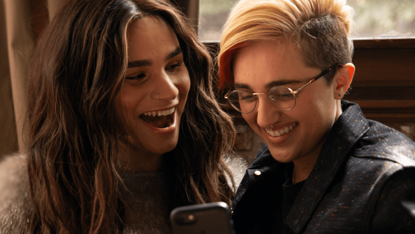 Two individuals laughing at a phone