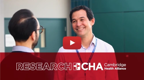 Video still of researcher smiling outside with their colleague