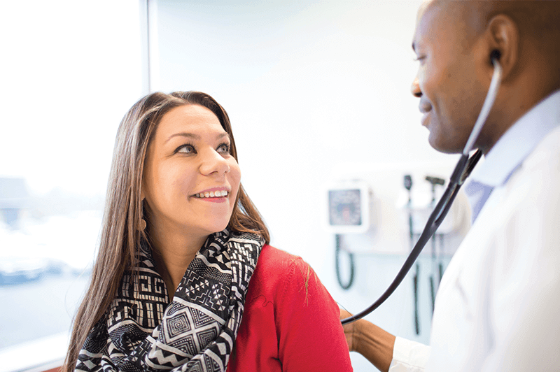 Dr. Ribourg and a female patient in the exam room