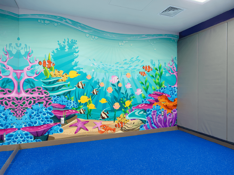 The sensory room with happy murals covering the walls.