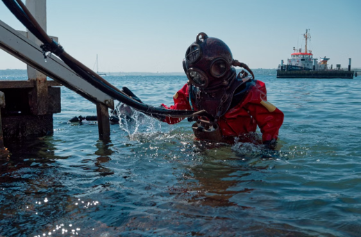 Image of a commercial diver in scuba gear coming out of the water