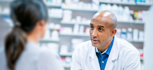 Pharmacist interacting with a customer across the counter