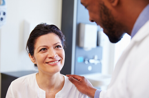 Provider reassuring a patient by touching her shoulder